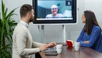 Colleagues in huddle meeting with video conferencing