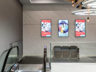 Digital signage screens at top of escalator