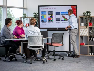 Man delivering presentation to team on interactive screen