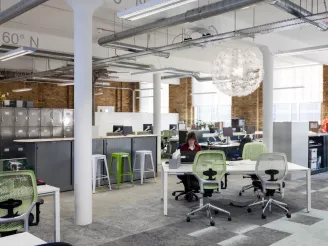 Woman sat working at a desk in a modern open plan office space