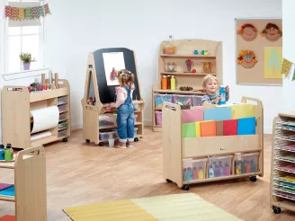 Boy and girl playing with arts and crafts in nursery with wooden nursery furniture