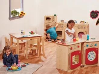 Children playing with wooden toy kitchen equipment in a nursery
