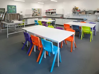 School desks in classroom with coloured chairs