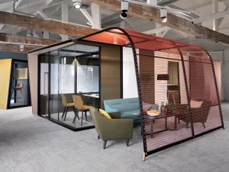 Modern meeting room pod in open plan office with sofas, table and comfy chairs