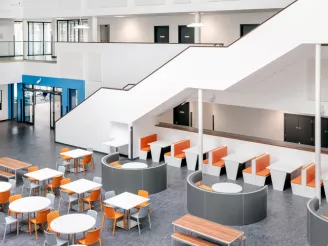 Office breakout space with orange, grey and white canteen furniture and huddle space furniture