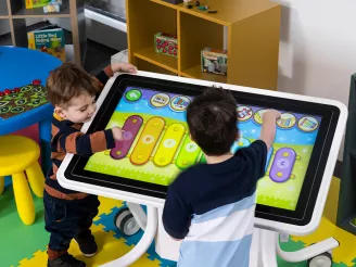 Children playing on interactive touchscreen table app