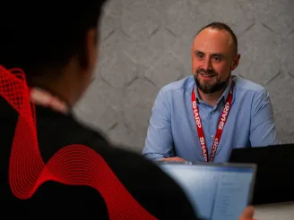 Man wearing Sharp lanyard having consultation with another man