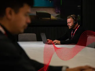 Man with Sharp lanyard using laptop