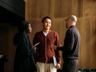 Three people stood up talking