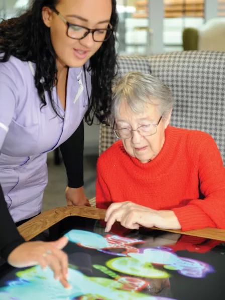 An image of an Interactive Touchscreen Table being used at New Care.