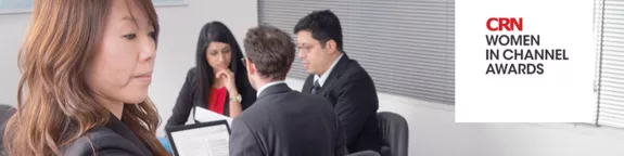 Close up of a woman with a team meeting in the background