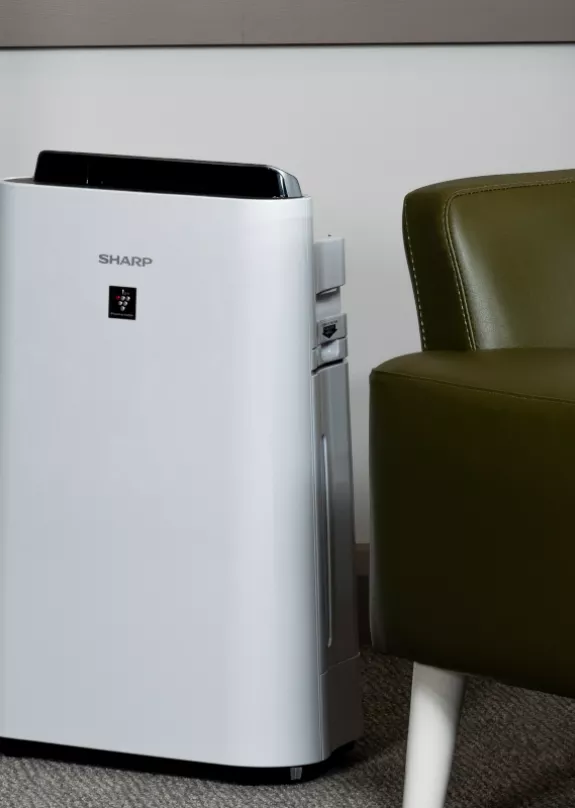 Plasmacluster air purifier next to armchair