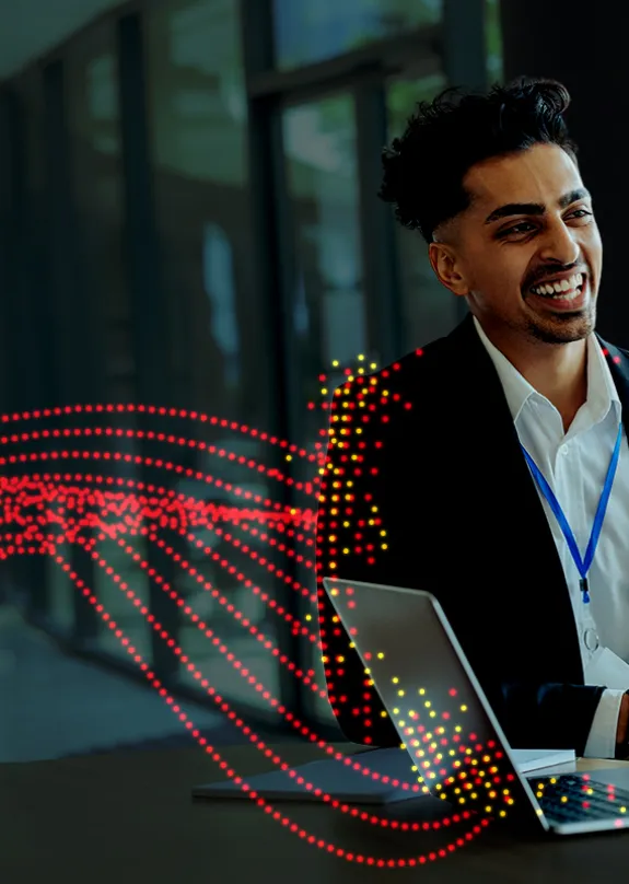Two men sat chatting by a laptop