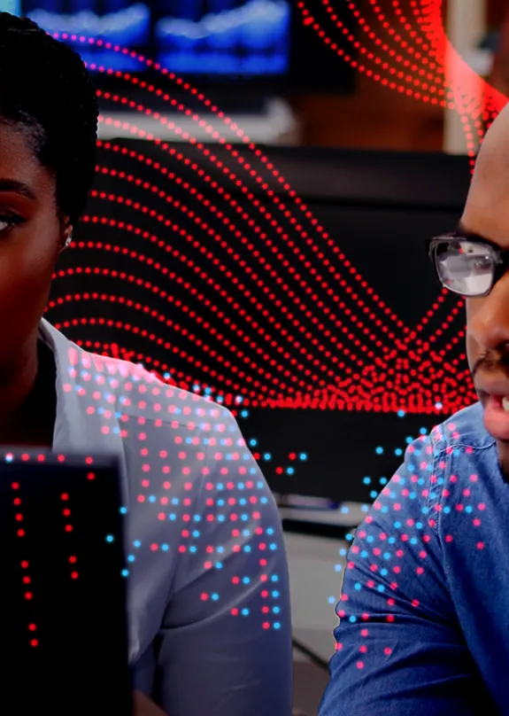 Man and woman both looking at a computer monitor 