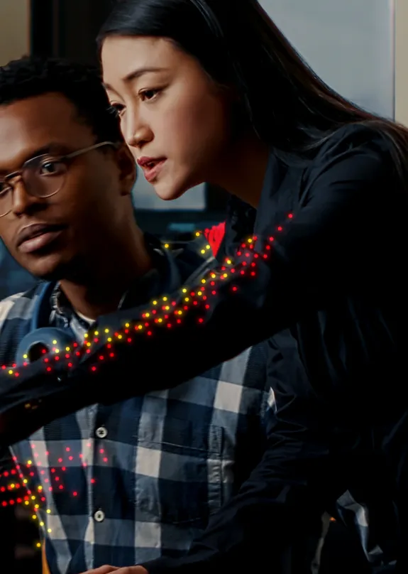 Man and woman both looking at a computer monitor