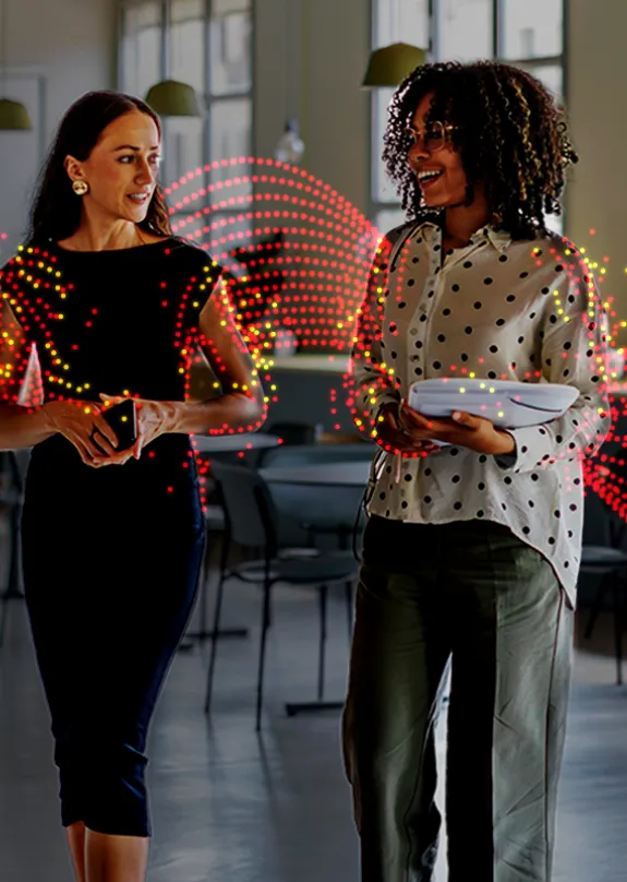 Two women walking through an office environment