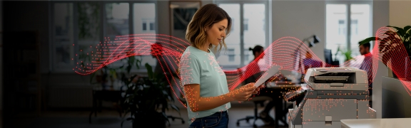 Woman standing in front of a Sharp MFP looking at a piece of paper