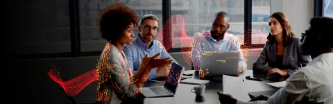 Group of people having a team meeting around a table with laptops in front of them