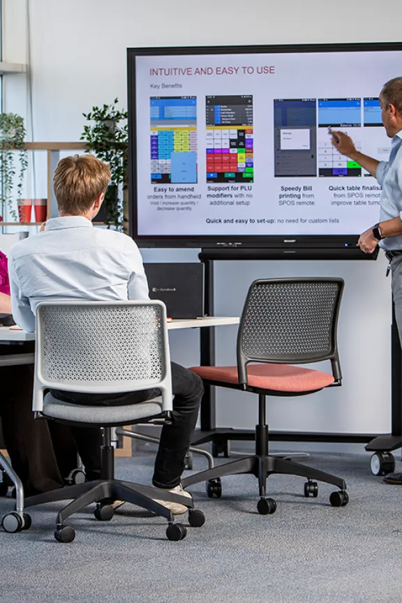 Man delivering presentation to team on interactive screen