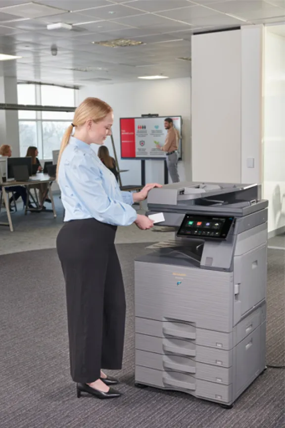 Women standing in front of a Sharp photocopier